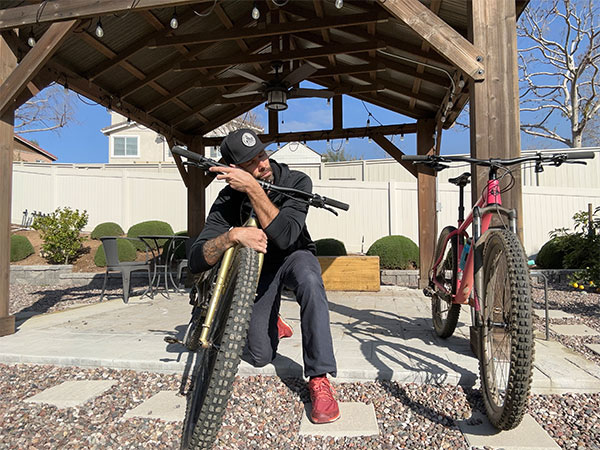 Colin on bent knee hugging his rigid Karate Monkey bike