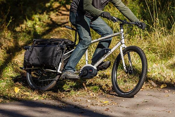 Cyclist riding over grass and pavement on a Surly Big Easy bike 