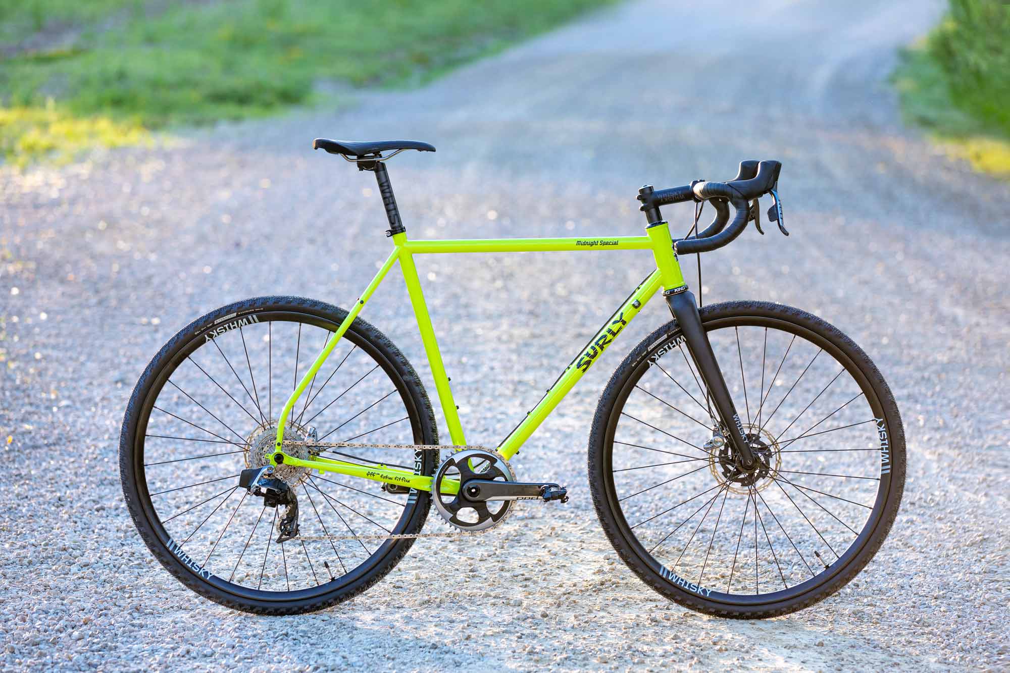 Custom Surly Midnight Special bike, lime green color, side view propped up on gravel road