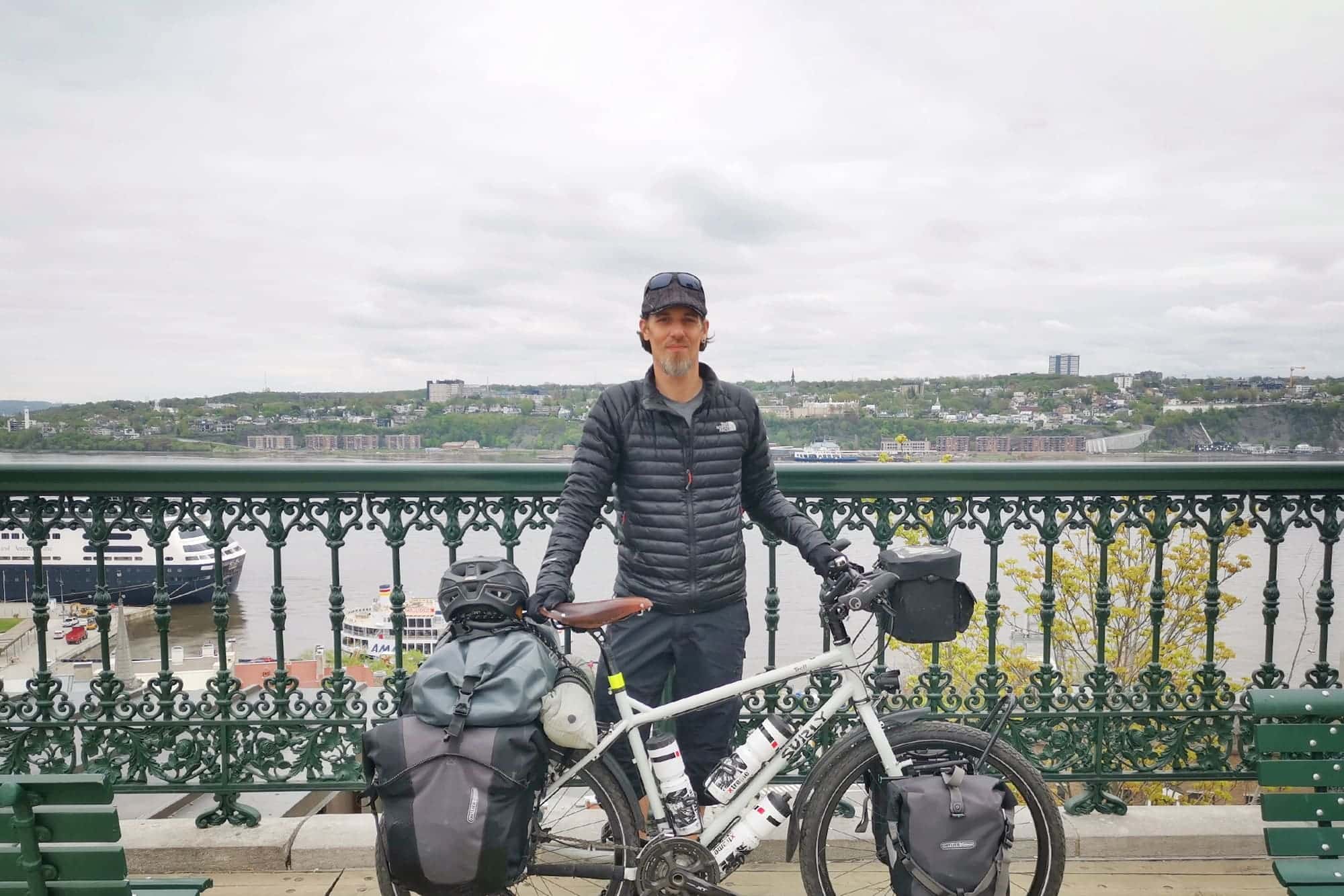 Yann standing with loaded Surly Troll bike in front of river overlook