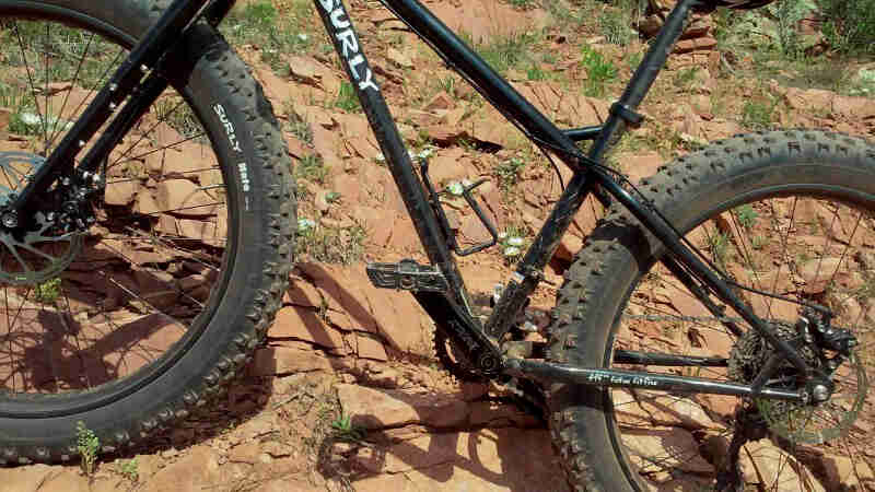 Cropped right side view of a Surly Ice Cream Truck fat bike, black, parked on a rocky hill