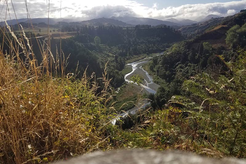 View from atop a ridge looking down on river in lush valley