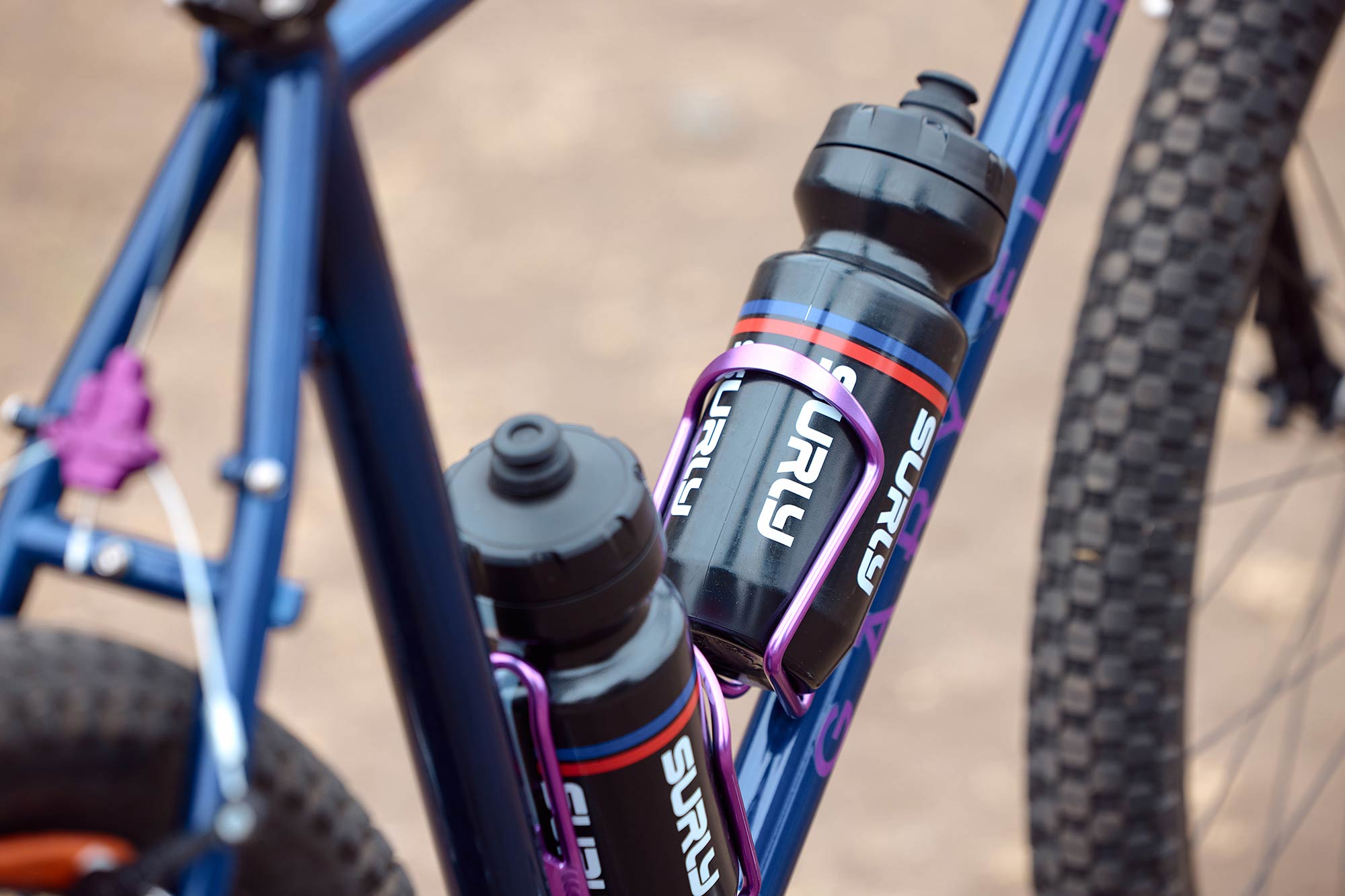 Close-up of purple annodized water bottle cages on HooKooEKoo frame with Surly Intergalactic waterbottles