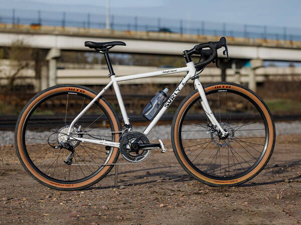 Surly Midnight Special bike side view near railroad tracks, hiway overpass in background