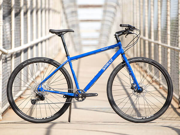 Surly Bridge Club bike, blue color, side view on fenced pedestrian bridge 