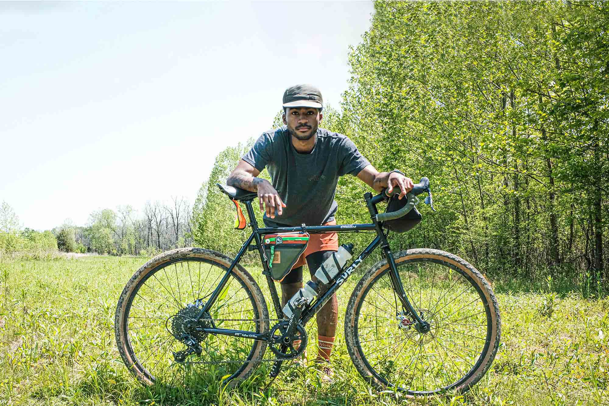 Caz standing behind Surly Straggler in tall grass